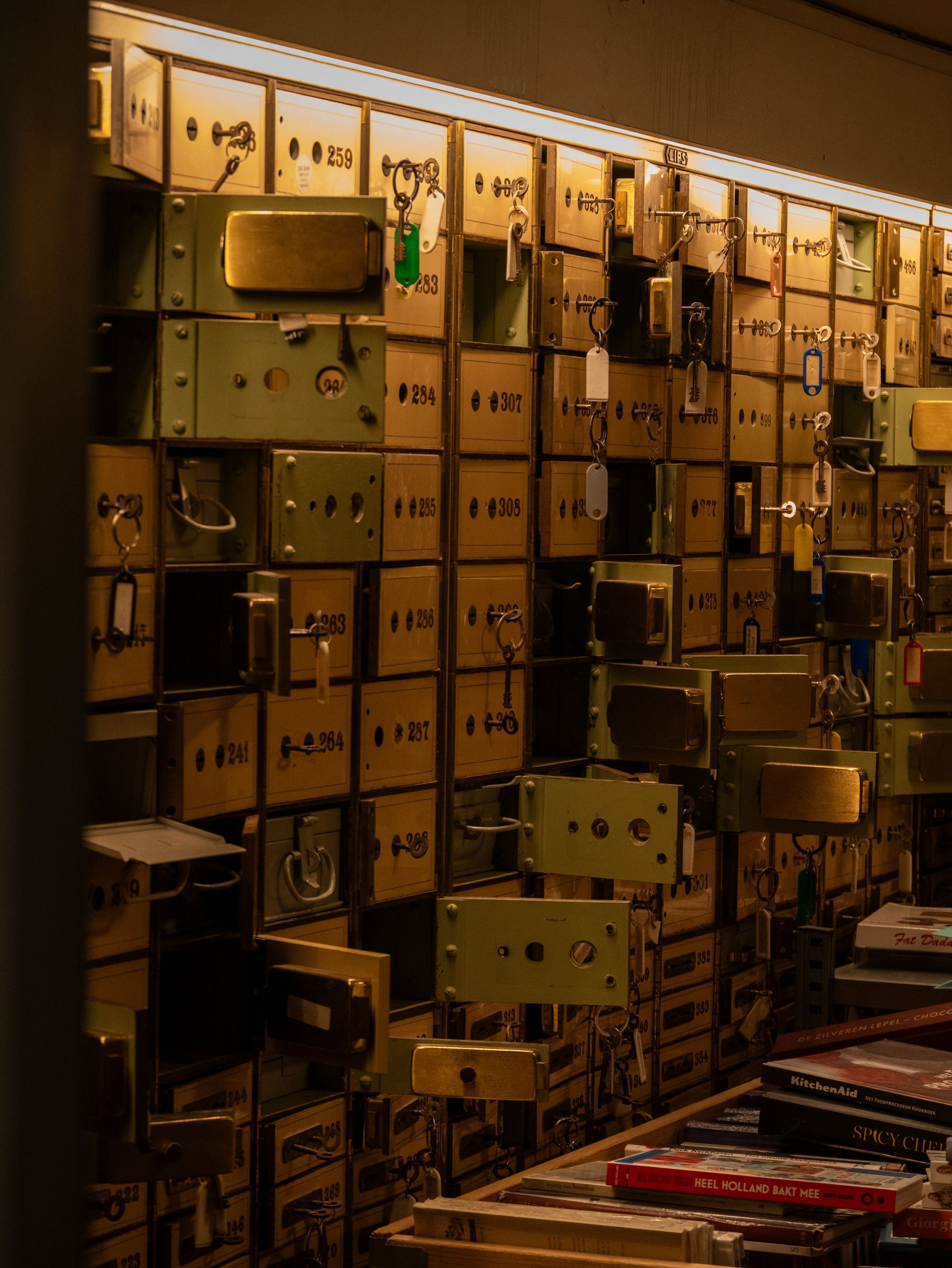 Old deposit boxes with keys in their locks, in amber light